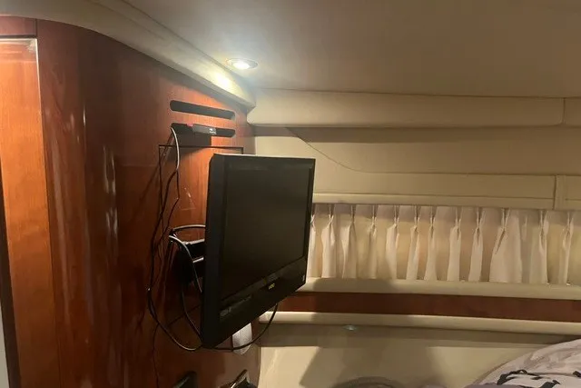 Slide: The Image of Interior of 2005 Sea Ray Sundancer 260 with mounted TV and wood paneling. - 17