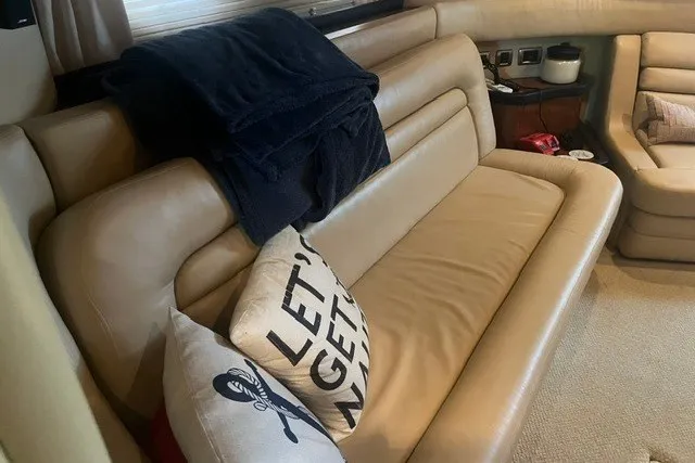 Slide: The Image of Interior of 2005 Sea Ray Sundancer 260 with beige leather seating and decorative pillows. - 22
