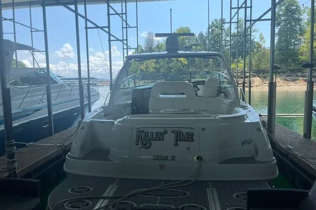 Slide: The Image of 2005 Sea Ray Sundancer 260 docked, rear view with "Killin' Time" name, under a canopy. - 9