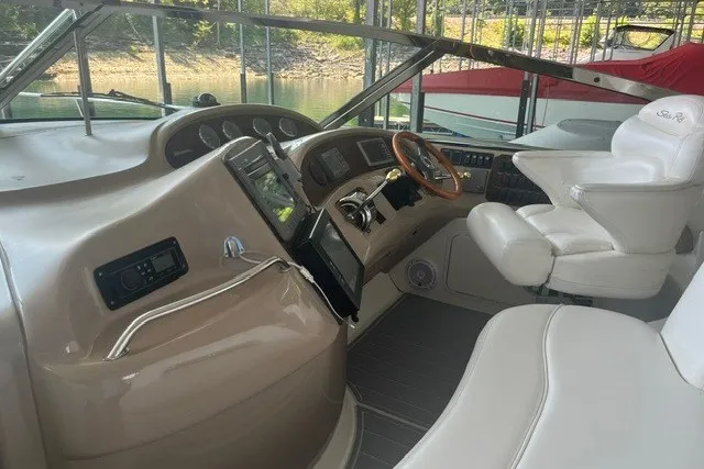 Slide: The Image of 2005 Sea Ray Sundancer 260 cockpit with beige dashboard and white captain's chair. - 13
