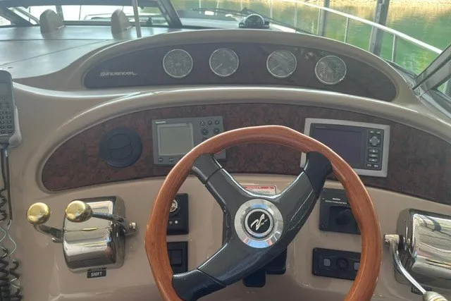 Slide: The Image of 2005 Sea Ray Sundancer 260 helm with wood steering wheel and navigation instruments. - 11