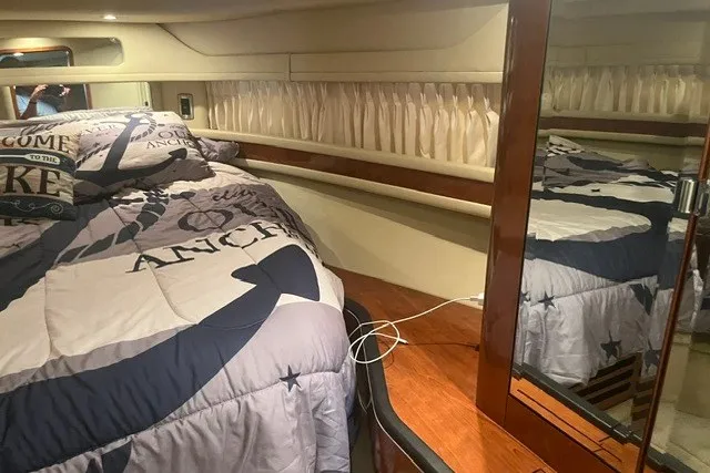 Slide: The Image of Interior cabin of 2005 Sea Ray Sundancer 260 with nautical-themed bedding. - 19