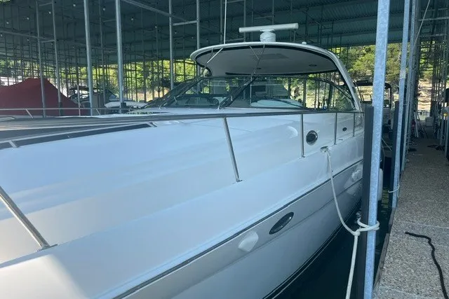 Slide: The Image of 2005 Sea Ray Sundancer 260 docked in a covered marina, showcasing sleek white exterior. - 5
