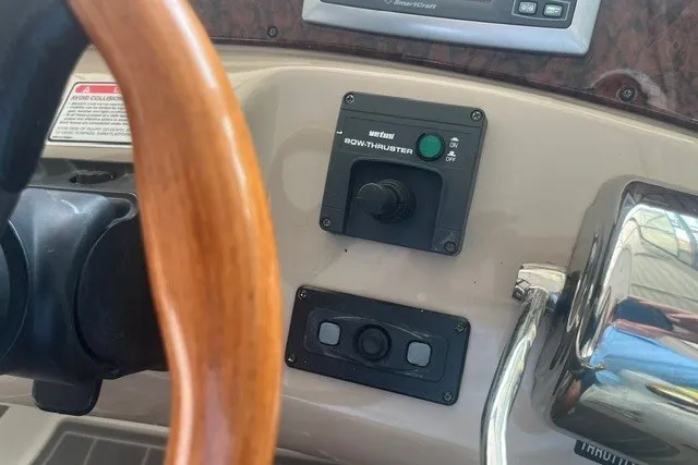 Slide: The Image of 2005 Sea Ray Sundancer 260 helm with bow thruster controls and wooden steering wheel. - 12