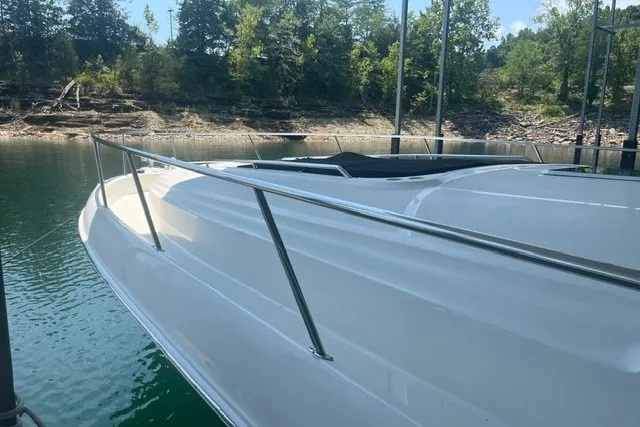 Slide: The Image of 2005 Sea Ray Sundancer 260 docked on a serene lake with lush greenery. - 7