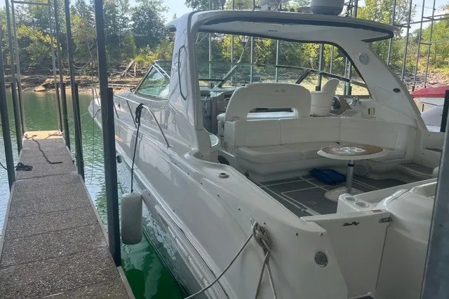 Slide: The Image of 2005 Sea Ray Sundancer 260 docked, showcasing spacious white interior and sleek design. - 8