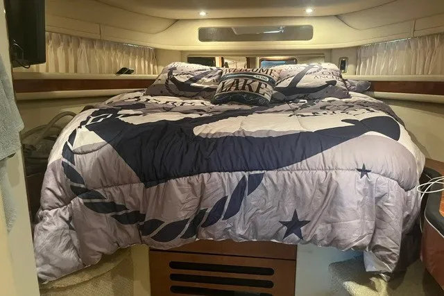Slide: The Image of Interior cabin of a 2005 Sea Ray Sundancer 260 with nautical-themed bedding. - 18