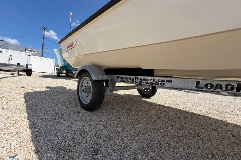 Slide: The Image of 1969 Boston Whaler 13 Super Sport on trailer, parked on gravel under clear blue sky. - 20