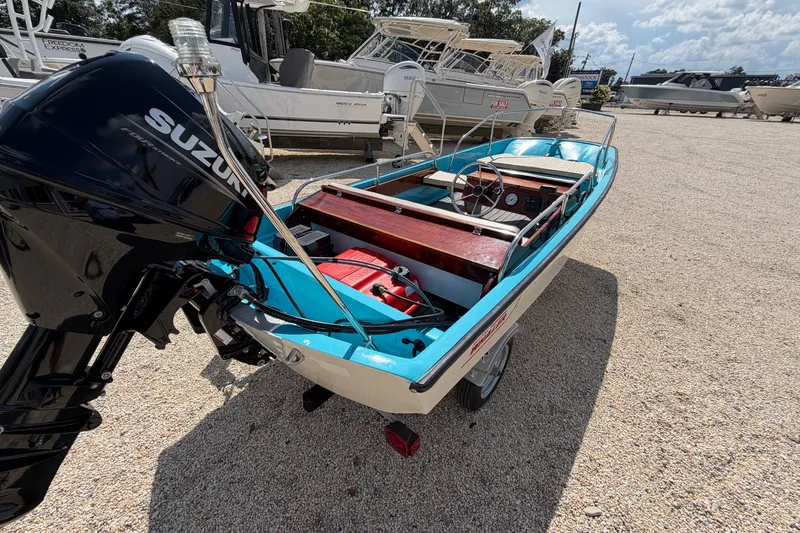 Slide: The Image of 1969 Boston Whaler 13 Super Sport boat with Suzuki outboard motor on display. - 2
