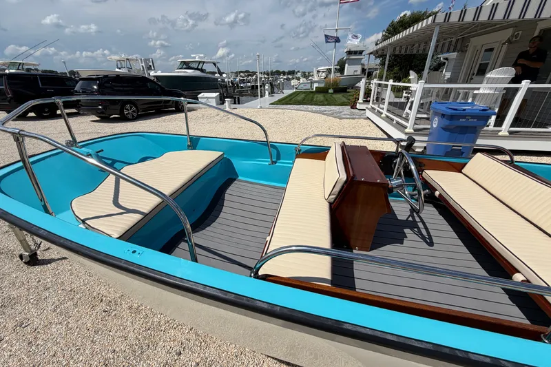 Slide: The Image of 1969 Boston Whaler 13 Super Sport boat with blue interior and beige seating at a marina. - 8