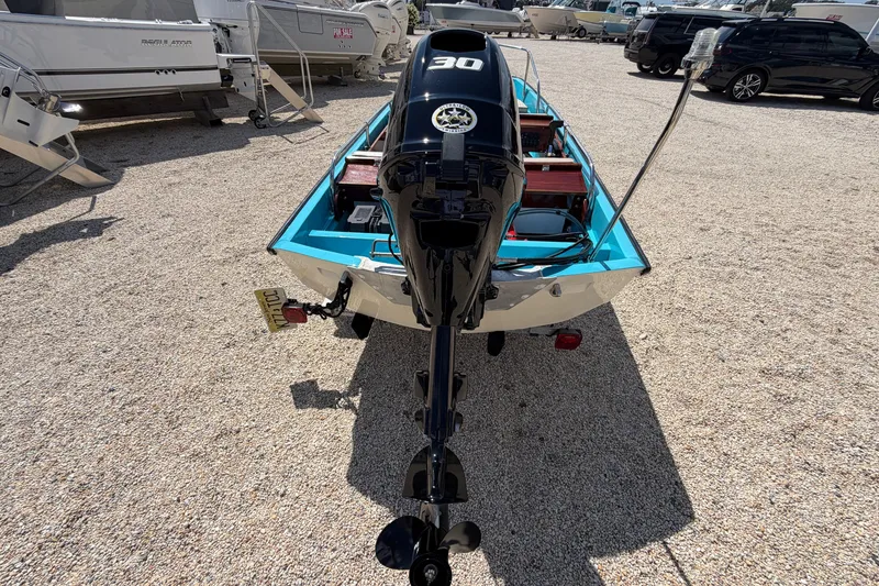 Slide: The Image of 1969 Boston Whaler 13 Super Sport boat with outboard motor, parked on gravel lot. - 5