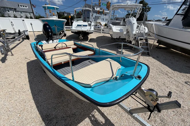 Slide: The Image of 1969 Boston Whaler 13 Super Sport boat with blue hull on a trailer in a marina. - 10