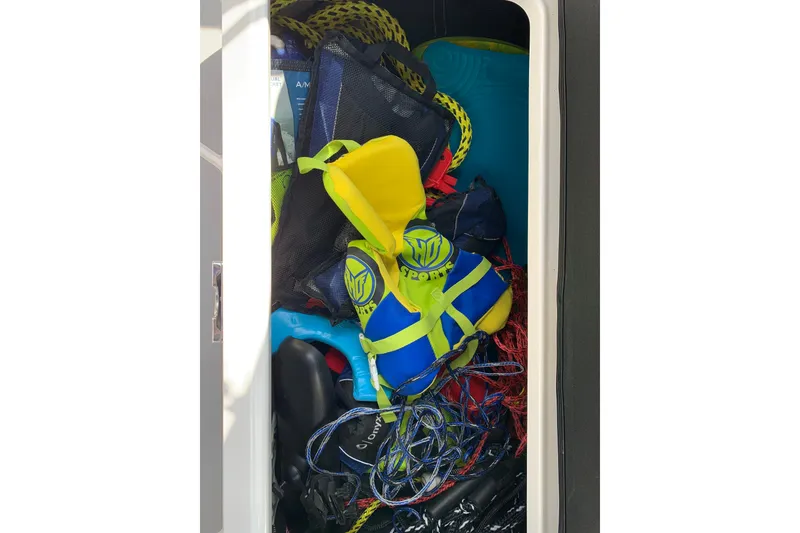 Slide: The Image of Storage compartment of 2020 Regal LS6 Surf boat with life jackets and ropes. - 63