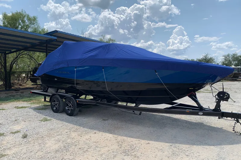 Slide: The Image of 2020 Regal LS6 Surf boat covered on trailer under a blue sky. - 77