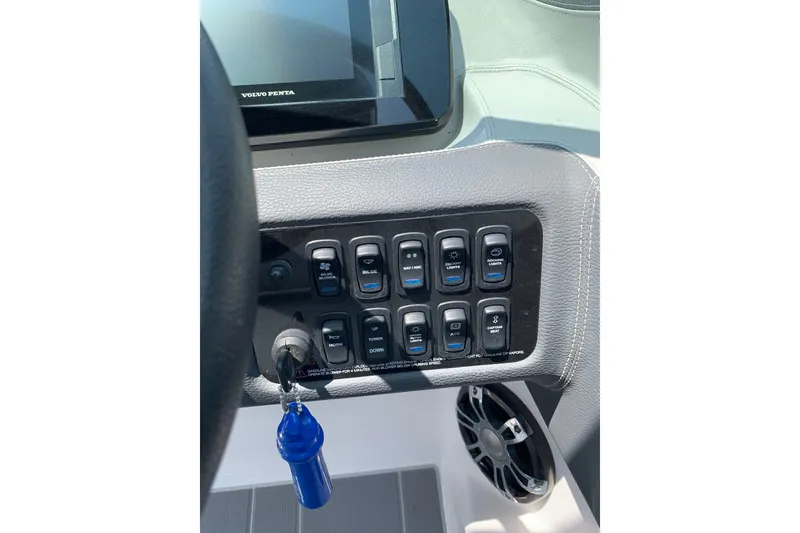 Slide: The Image of Control panel of a 2020 Regal LS6 Surf boat with switches and key. - 32