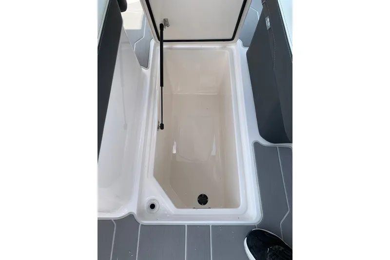 Slide: The Image of 2020 Regal LS6 Surf boat storage compartment with open lid, showcasing interior space. - 36