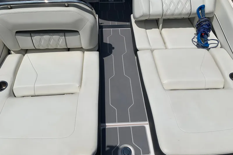 Slide: The Image of 2020 Regal LS6 Surf boat interior with white cushioned seating and deck details. - 9
