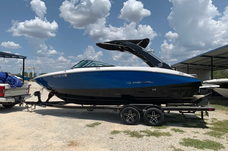 Slide: The Image of 2020 Regal LS6 Surf boat on trailer under cloudy sky. - 4