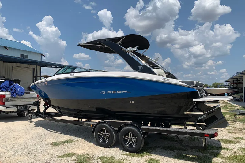 Slide: The Image of 2020 Regal LS6 Surf boat on trailer under a cloudy sky. - 3