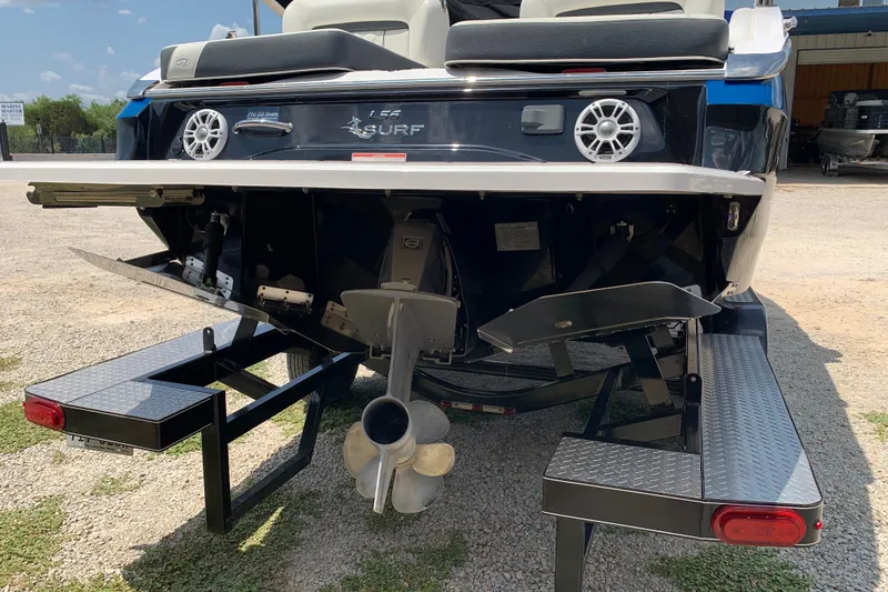 Slide: The Image of Rear view of a 2020 Regal LS6 Surf boat on a trailer, showcasing propeller and surf system. - 72