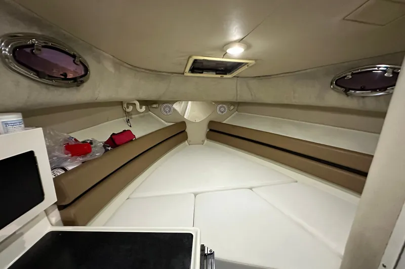 Slide: The Image of Interior cabin of 2002 Hydra-Sports Vector 2800 WA boat, featuring seating and portholes. - 10