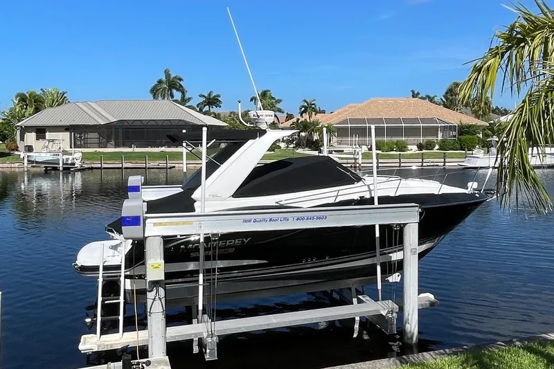 Slide: The Image of 2017 Monterey 295 Sport Yacht docked on a lift in a sunny waterfront setting. - 29