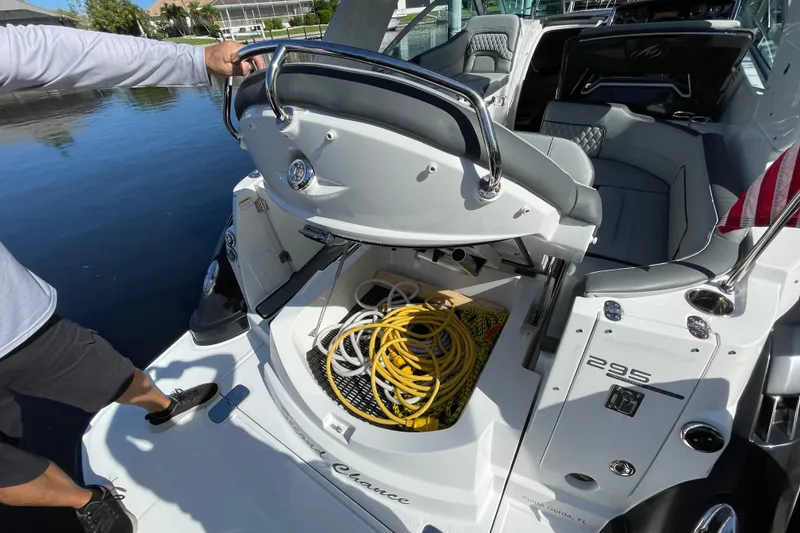 Slide: The Image of 2017 Monterey 295 Sport Yacht with open storage compartment, docked by calm water. - 18