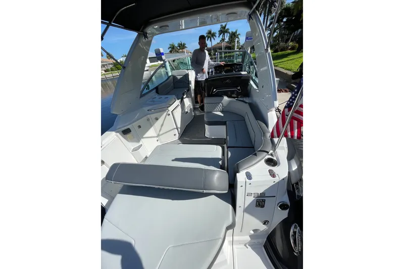 Slide: The Image of 2017 Monterey 295 Sport Yacht interior with seating and helm, docked near water. - 19