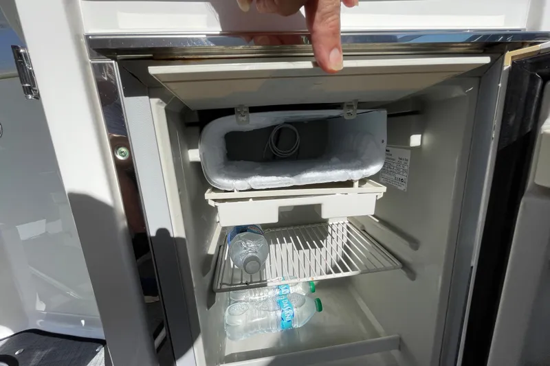 Slide: The Image of Open mini fridge on 2017 Monterey 295 Sport Yacht with water bottles inside. - 24