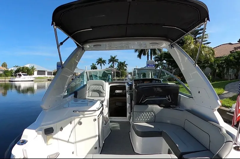 Slide: The Image of 2017 Monterey 295 Sport Yacht interior with seating, canopy, and waterfront view. - 33