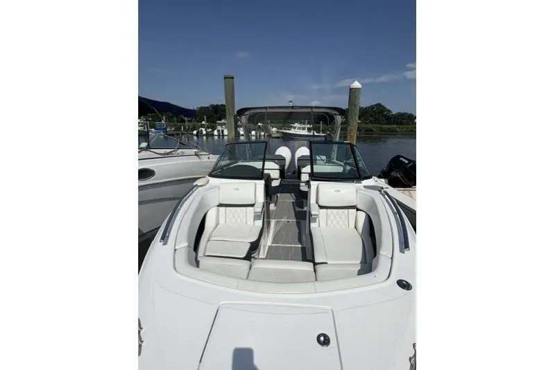 Slide: The Image of 2023 Regal 29 OBX boat with luxurious seating, docked at a marina under clear skies. - 17