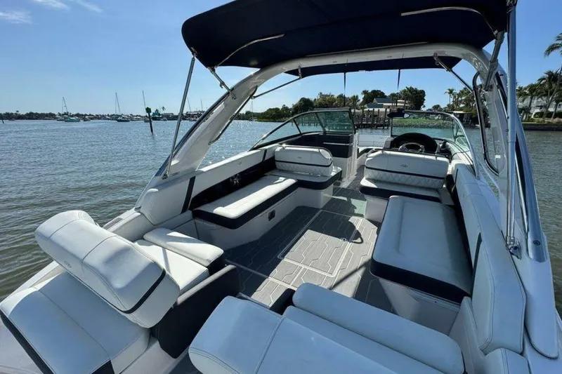 Slide: The Image of 2023 Regal 29 OBX boat interior with spacious seating and canopy on a sunny day. - 33