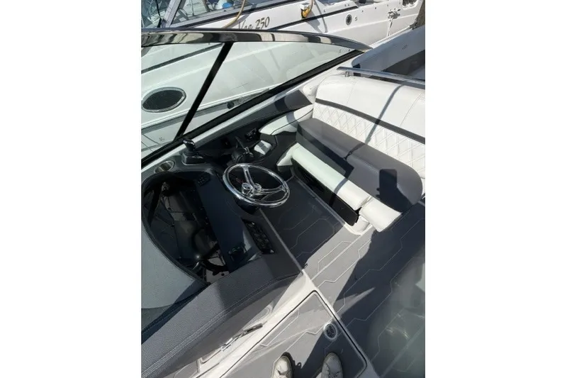 Slide: The Image of 2023 Regal 29 OBX boat interior with sleek steering and modern seating design. - 32
