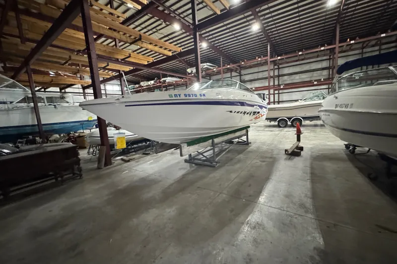 Slide: The Image of 2009 Baja 24 H2X Boss boat stored indoors in a spacious warehouse. - 13