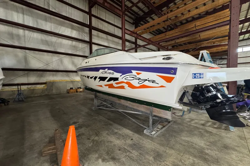 Slide: The Image of 2009 Baja 24 H2X Boss boat in storage, featuring vibrant graphics and sleek design. - 22