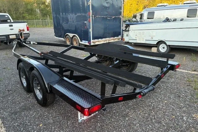 Slide: The Image of Black boat trailer for 2009 Baja 24 H2X Boss, parked on gravel lot. - 43