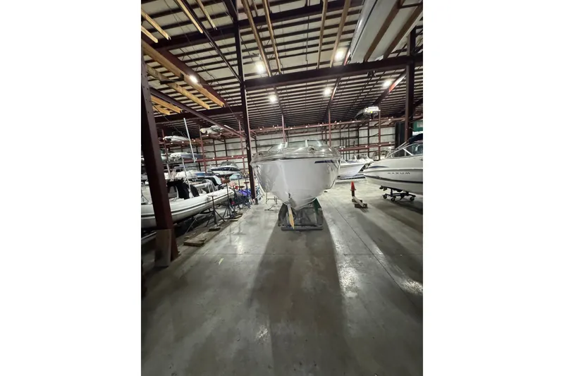 Slide: The Image of 2009 Baja 24 H2X Boss boat stored in a spacious indoor facility. - 20