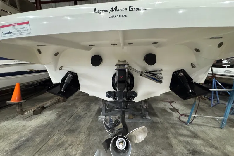 Slide: The Image of Rear view of a 2009 Baja 24 H2X Boss boat in a garage setting. - 24