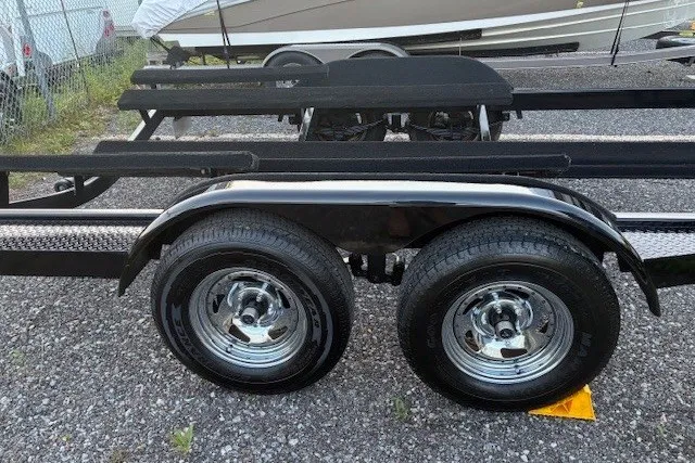 Slide: The Image of Trailer for 2009 Baja 24 H2X Boss boat with dual wheels on gravel. - 45