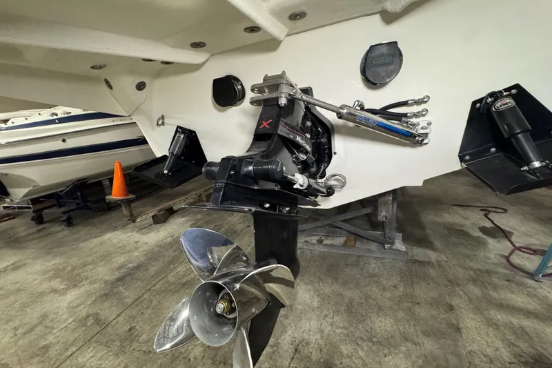 Slide: The Image of 2009 Baja 24 H2X Boss boat with visible propeller and engine components in a garage. - 26