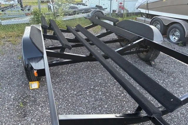 Slide: The Image of Boat trailer for 2009 Baja 24 H2X Boss on gravel lot near fence. - 46