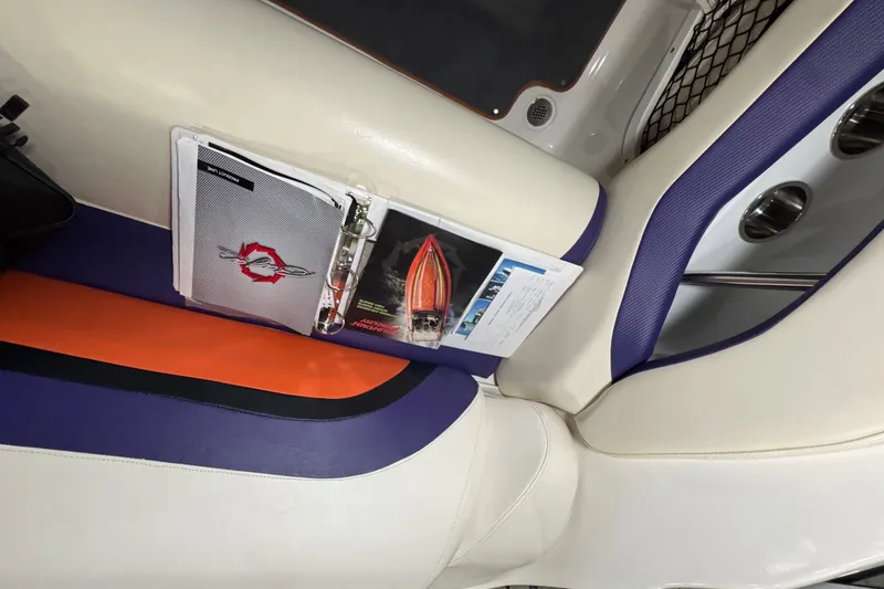 Slide: The Image of Interior of 2009 Baja 24 H2X Boss boat with manuals and vibrant seating. - 35