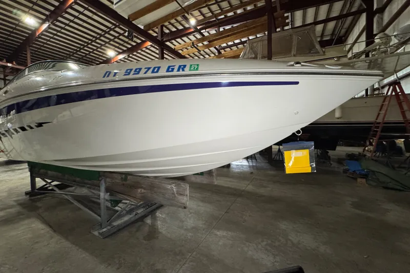 Slide: The Image of 2009 Baja 24 H2X Boss boat in storage, showcasing sleek white hull and blue accents. - 19
