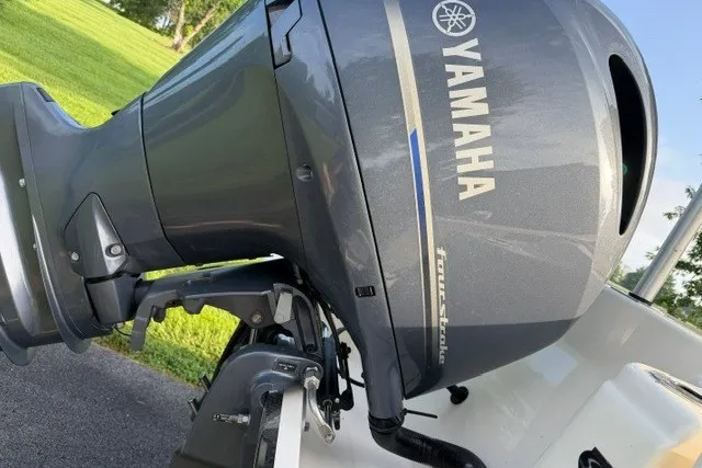 Slide: The Image of 2020 Scout 215 XSF boat with Yamaha outboard motor, parked on grass. - 25