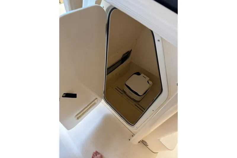 Slide: The Image of 2020 Scout 215 XSF boat storage compartment with portable toilet inside. - 21