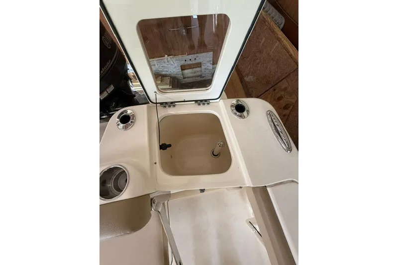 Slide: The Image of 2020 Scout 215 XSF boat interior with open storage compartment and cup holders. - 14
