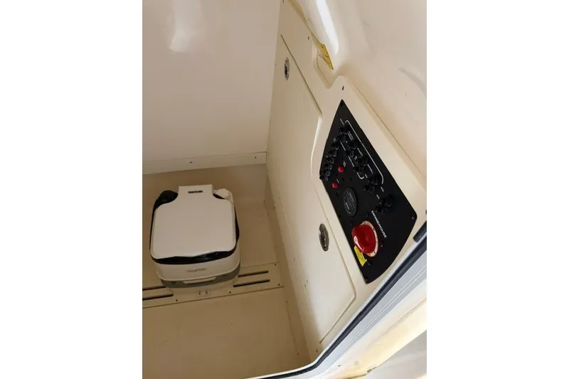 Slide: The Image of 2020 Scout 215 XSF boat interior with control panel and portable toilet. - 19