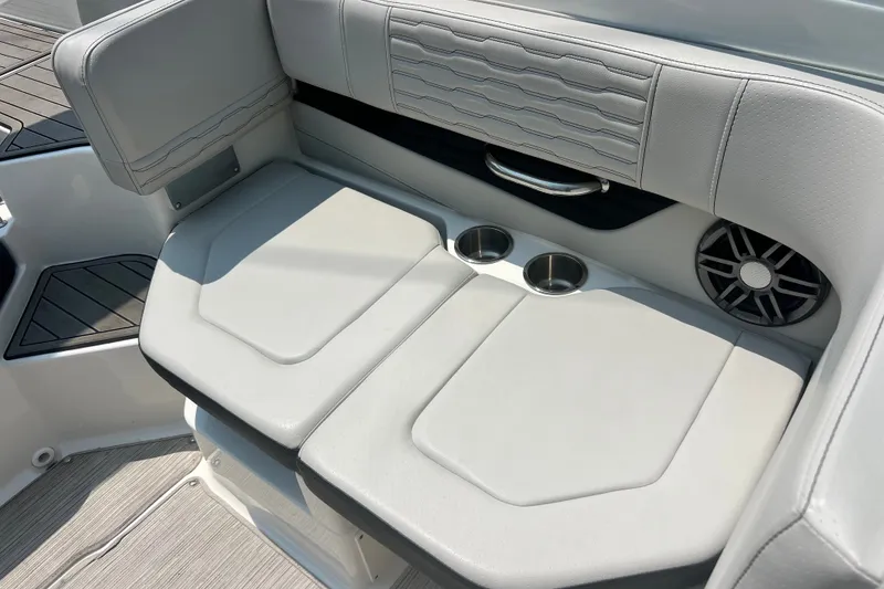 Slide: The Image of 2023 Sea Ray SPX 190 boat interior with cushioned seating, cup holders, and speaker. - 23