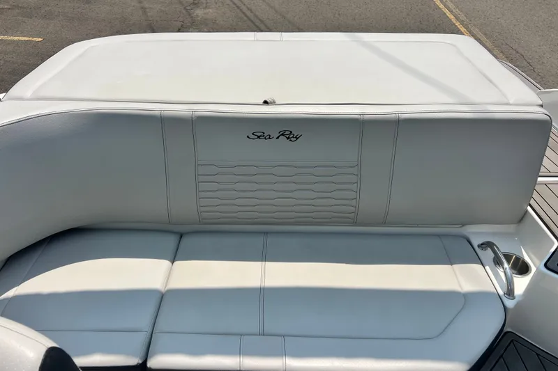 Slide: The Image of 2023 Sea Ray SPX 190 boat interior with white cushioned seating and logo. - 25