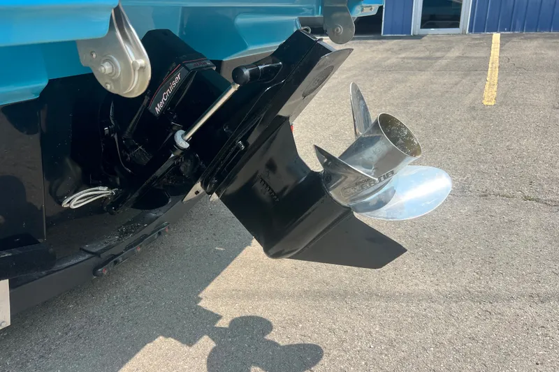 Slide: The Image of 2023 Sea Ray SPX 190 boat with MerCruiser outboard motor and propeller on pavement. - 2